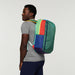 Person modeling the Cotopaxi Batac backpack with distinctive rainbow stripe