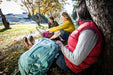 Group of women lounging outdoors, each with an Osprey Celeste backpack