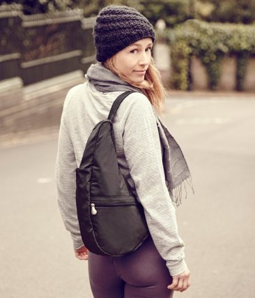 Lifestyle shot of a woman outdoors wearing the AmeriBag Healthy Back Bag with a hat