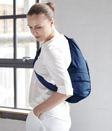 Side view of a woman carrying the AmeriBag Healthy Back Bag