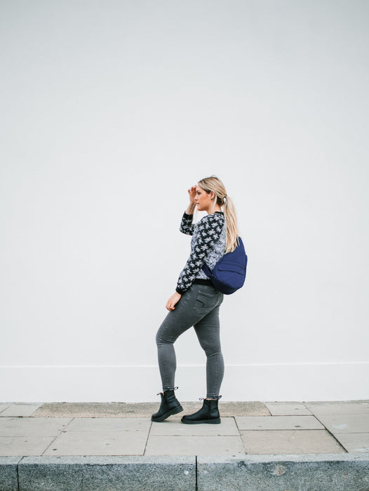 Woman standing on a sidewalk modeling the AmeriBag Healthy Back Bag