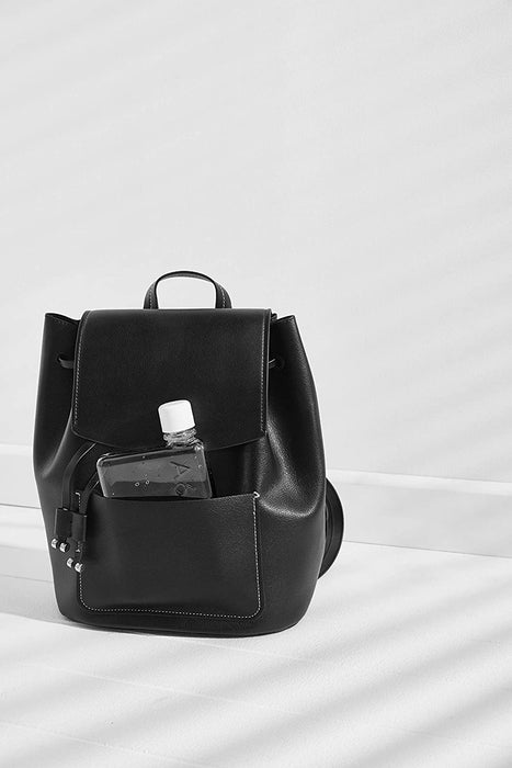 A6 memobottle in a side pocket of a black backpack beside a smartphone