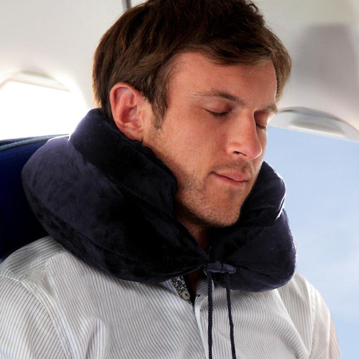 Traveler asleep on an airplane using the Air Evolution inflatable neck pillow