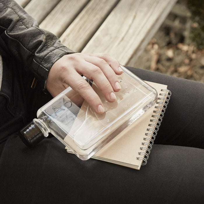 A6 memobottle on a bench next to a person with a notebook