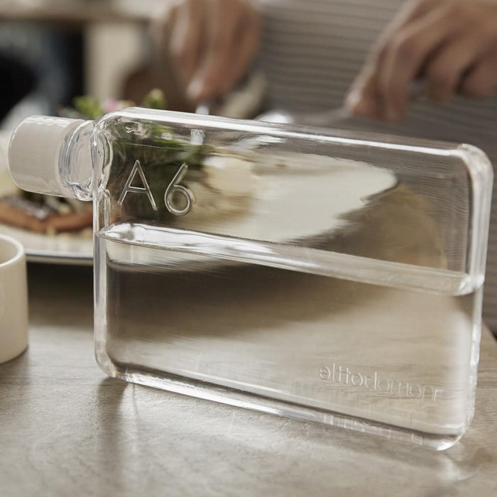 A6 memobottle placed on a dining table next to a meal