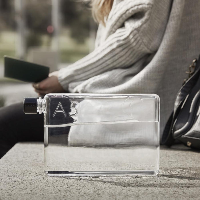 Clear A5 memobottle 750ml held by a woman on a bench