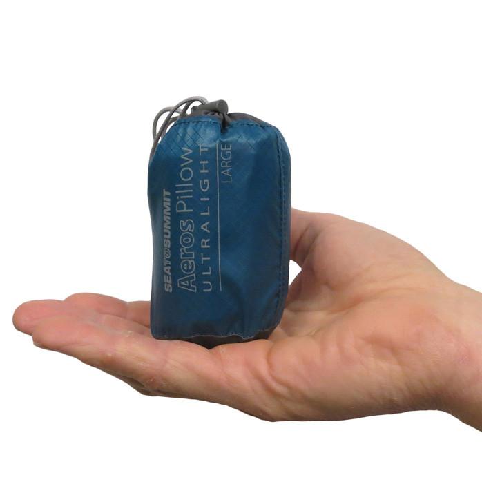 A compact blue travel bag with "Aeros Ultralight" branding in a hand
